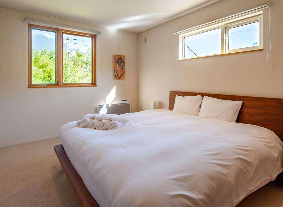 Experience tranquility in this inviting bedroom, featuring a comfortable bed and ample natural light.
