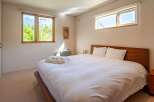Experience tranquility in this inviting bedroom, featuring a comfortable bed and ample natural light.