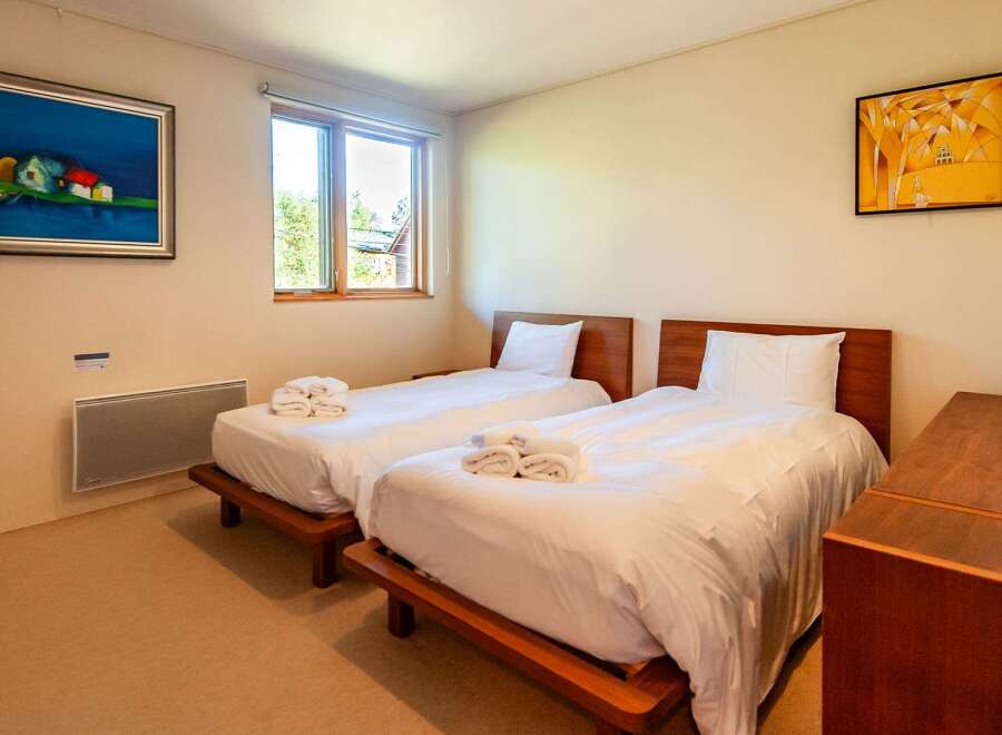 This cozy bedroom features two twin beds, perfect for guests or family members.
