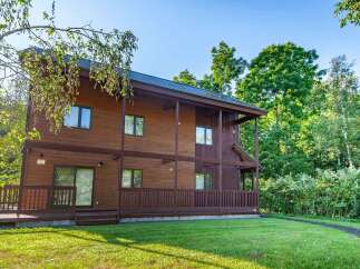 Discover the charm of this stunning wooden house nestled in a serene, tree-lined setting.