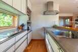 This modern kitchen boasts sleek stainless steel countertops and white cabinetry, creating a bright and airy space.