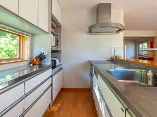 This modern kitchen boasts sleek stainless steel countertops and white cabinetry, creating a bright and airy space.