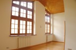 Bright and airy room with large multi-paned windows, hardwood floors, and modern radiators.