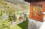 Mountain view home with a spacious balcony and large windows.