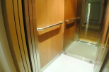 Modern elevator with wood paneling and stainless steel accents.