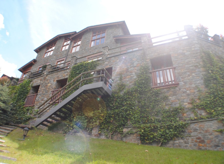 This stunning stone house boasts a multi-level design with expansive windows offering abundant natural light.