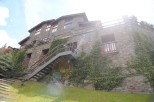 This stunning stone house boasts a multi-level design with expansive windows offering abundant natural light.