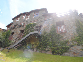 This stunning stone house boasts a multi-level design with expansive windows offering abundant natural light.