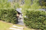 This secluded mountain home boasts a charming stone exterior, a slate roof, and a private courtyard with a metal gate.