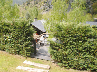 This secluded mountain home boasts a charming stone exterior, a slate roof, and a private courtyard with a metal gate.