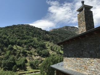 Mountain view home with stone exterior and a large chimney.
