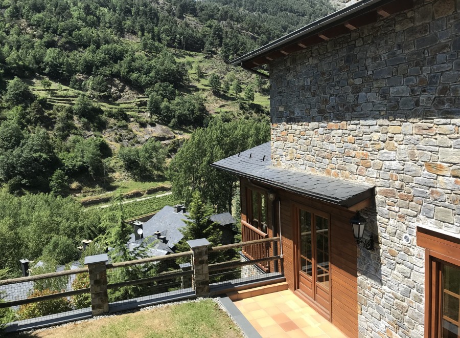 Mountain view home with stone exterior and wooden accents.