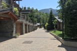 This stunning mountainside property boasts a charming row of stone houses, each with its own private garage.