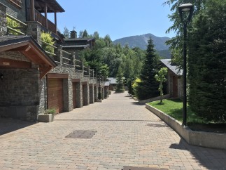 This stunning mountainside property boasts a charming row of stone houses, each with its own private garage.