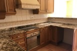 This stunning kitchen boasts beautiful wood cabinets and granite countertops, creating a luxurious feel.