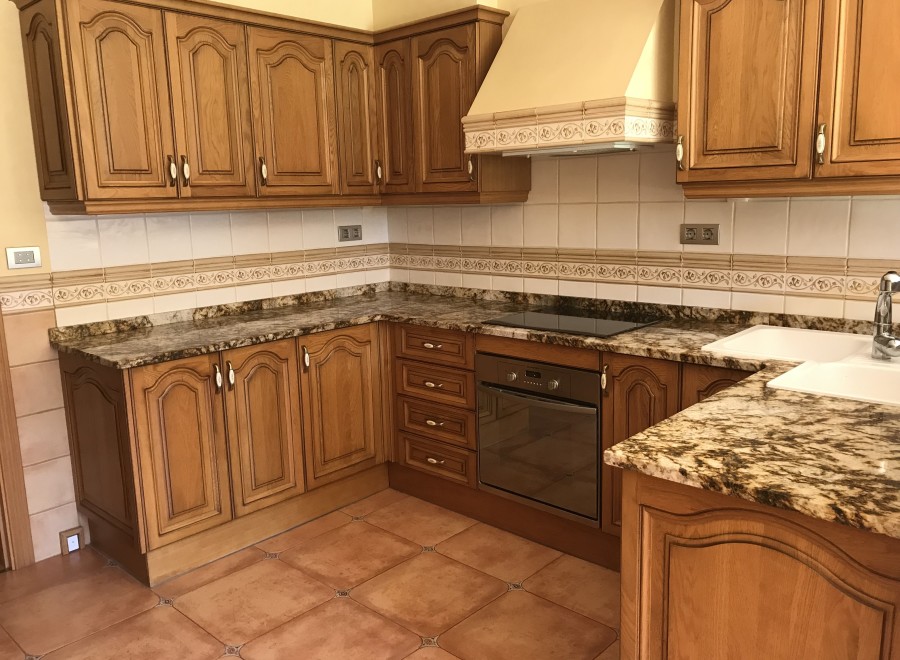 This beautiful kitchen boasts granite countertops and custom wooden cabinetry, creating a warm and inviting atmosphere.