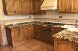 This beautiful kitchen boasts granite countertops and custom wooden cabinetry, creating a warm and inviting atmosphere.