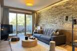 Experience luxury living in this stunning property, featuring a cozy living room with a stone wall and a plush rug.