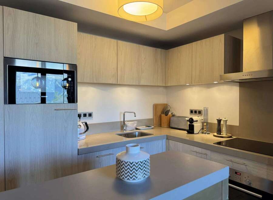 This modern kitchen boasts sleek cabinetry and stainless steel appliances, creating a stylish and functional space.