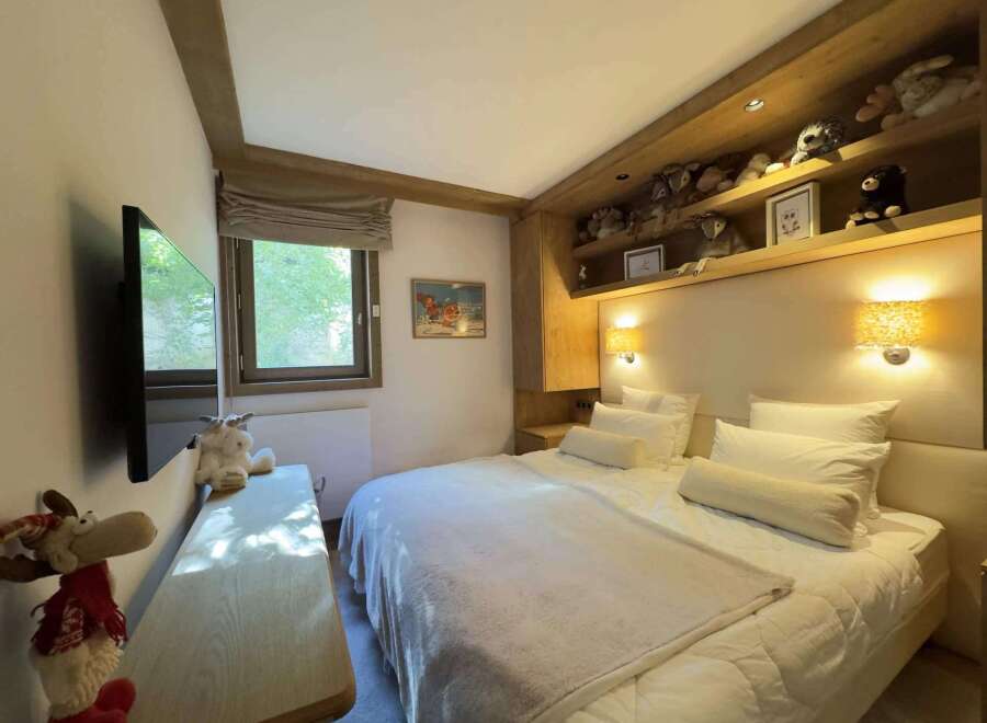 This cozy bedroom features a comfortable bed with plush pillows and a soft blanket, perfect for a relaxing stay.