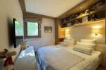 This cozy bedroom features a comfortable bed with plush pillows and a soft blanket, perfect for a relaxing stay.