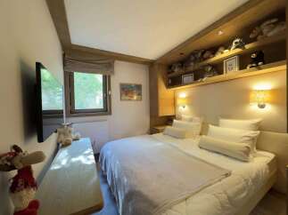 This cozy bedroom features a comfortable bed with plush pillows and a soft blanket, perfect for a relaxing stay.