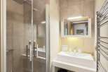 Step into this modern bathroom, featuring a sleek glass shower enclosure and contemporary fixtures.