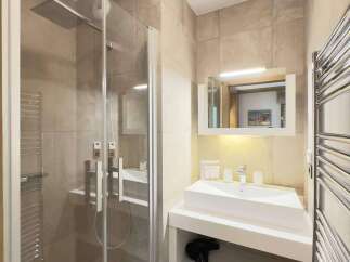 Step into this modern bathroom, featuring a sleek glass shower enclosure and contemporary fixtures.