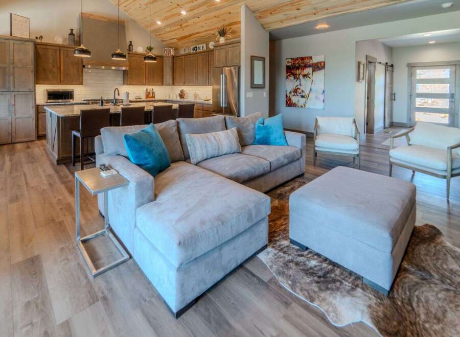 Step into luxury with this stunning property, showcasing a spacious living area with a comfortable sectional sofa and stylish ottoman.