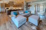 Step into luxury with this stunning property, showcasing a spacious living area with a comfortable sectional sofa and stylish ottoman.