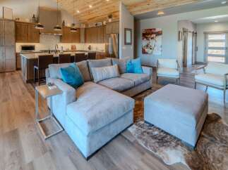 Step into luxury with this stunning property, showcasing a spacious living area with a comfortable sectional sofa and stylish ottoman.