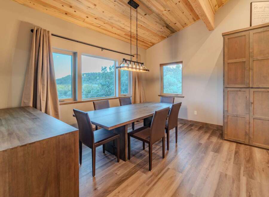 This stunning dining room features a beautiful wooden table and chairs, perfect for hosting dinner parties or enjoying family meals.