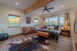 Experience luxury in this stunning bedroom featuring a rustic wooden dresser and a cozy leather bench.