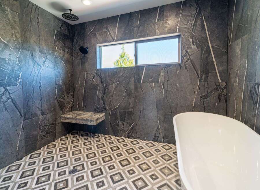 Step into luxury with this stunning bathroom featuring exquisite marble-like tilework.