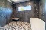 Step into luxury with this stunning bathroom featuring exquisite marble-like tilework.