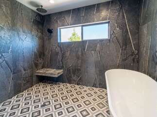 Step into luxury with this stunning bathroom featuring exquisite marble-like tilework.