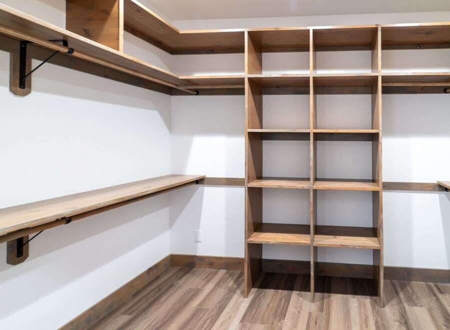 This custom closet offers ample storage with its built-in shelving and hanging rods.