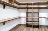 This custom closet offers ample storage with its built-in shelving and hanging rods.