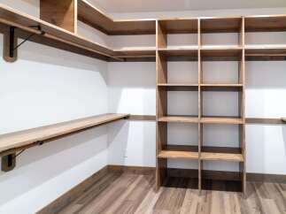This custom closet offers ample storage with its built-in shelving and hanging rods.