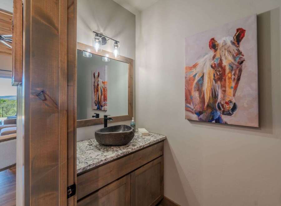 This stunning bathroom features a unique stone sink and a beautiful granite countertop, creating a luxurious and inviting space.