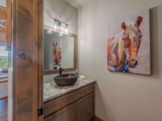 This stunning bathroom features a unique stone sink and a beautiful granite countertop, creating a luxurious and inviting space.