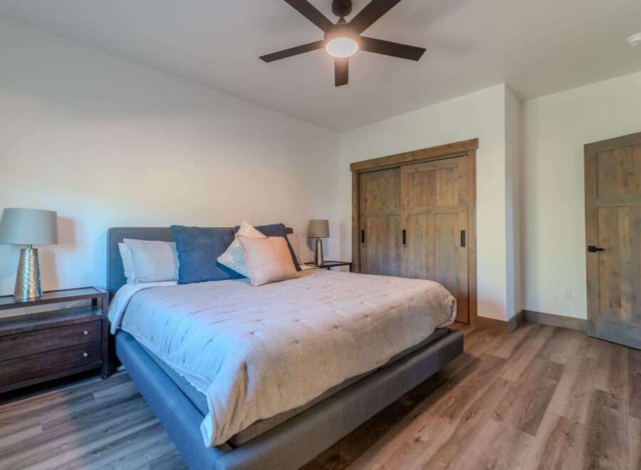 This inviting bedroom showcases a comfortable bed with stylish bedding and accent pillows.