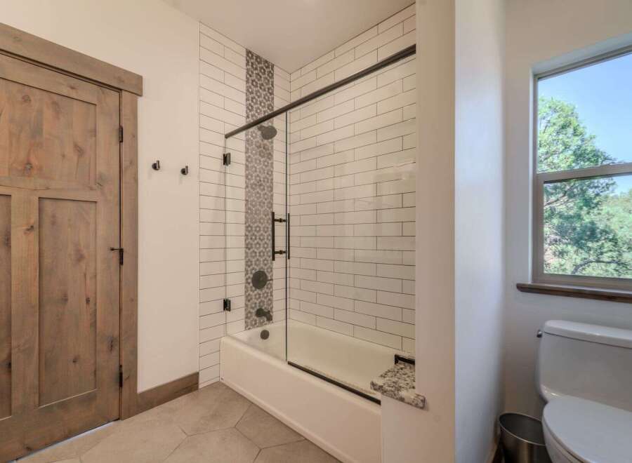 Step into a beautifully designed bathroom featuring a modern shower with glass doors and stylish tile work.