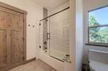 Step into a beautifully designed bathroom featuring a modern shower with glass doors and stylish tile work.