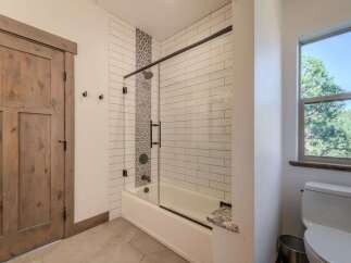 Step into a beautifully designed bathroom featuring a modern shower with glass doors and stylish tile work.