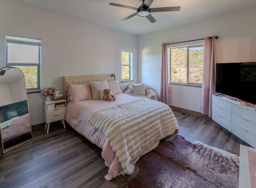 This charming bedroom offers a cozy retreat with its plush bedding and inviting ambiance.