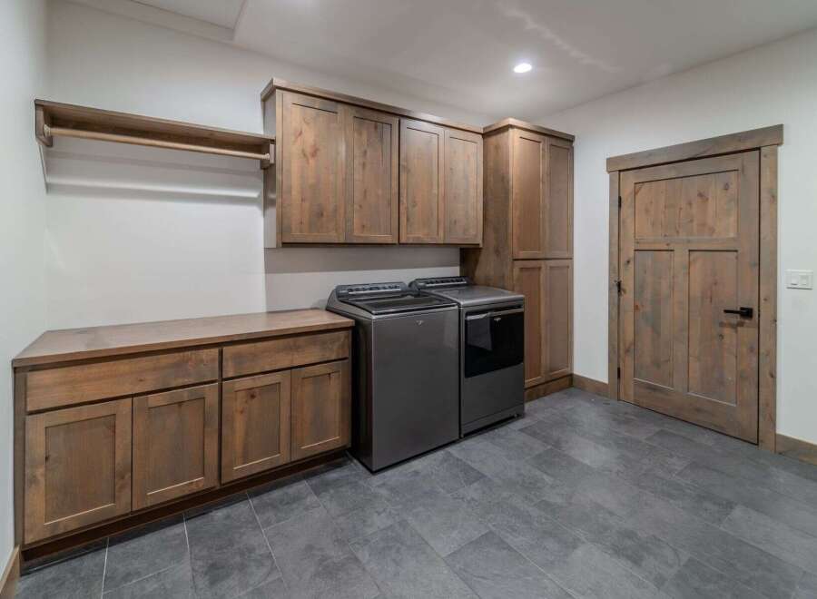 This stunning laundry room boasts a modern design with ample storage and functionality.