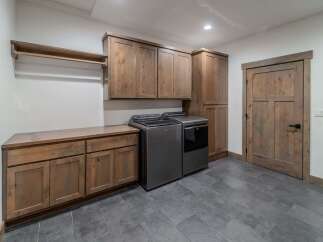 This stunning laundry room boasts a modern design with ample storage and functionality.