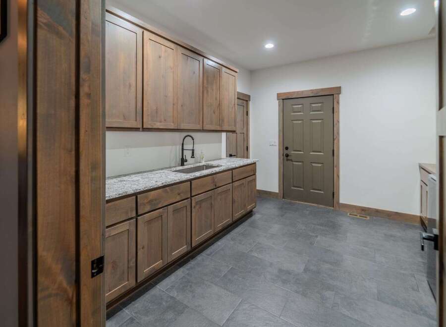 This stunning kitchen features custom wooden cabinetry, offering ample storage and a warm, inviting atmosphere.