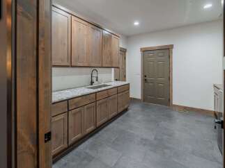 This stunning kitchen features custom wooden cabinetry, offering ample storage and a warm, inviting atmosphere.